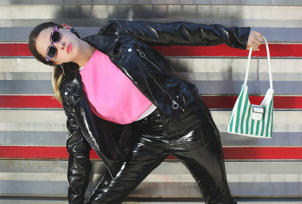 model in patent leather posing outside a diner.