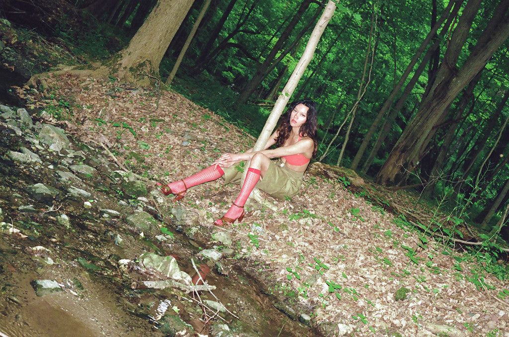 model posing on bank of a creek. 