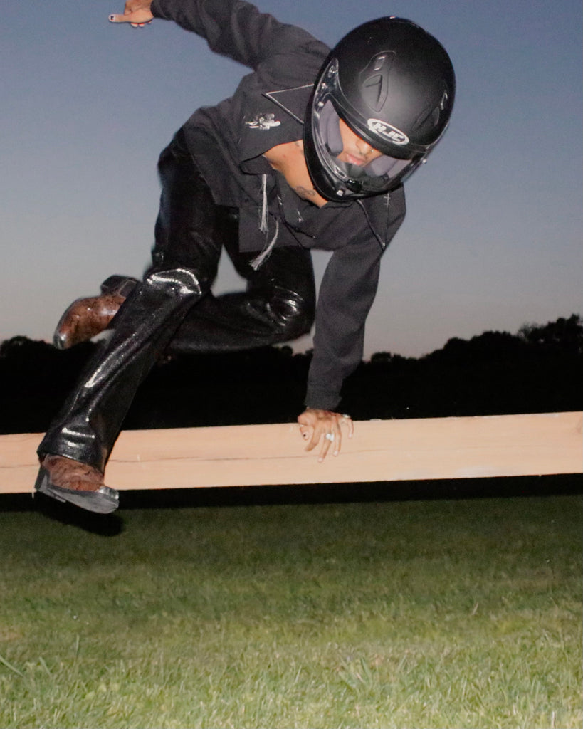 andre molina in full look jumping over a fence.