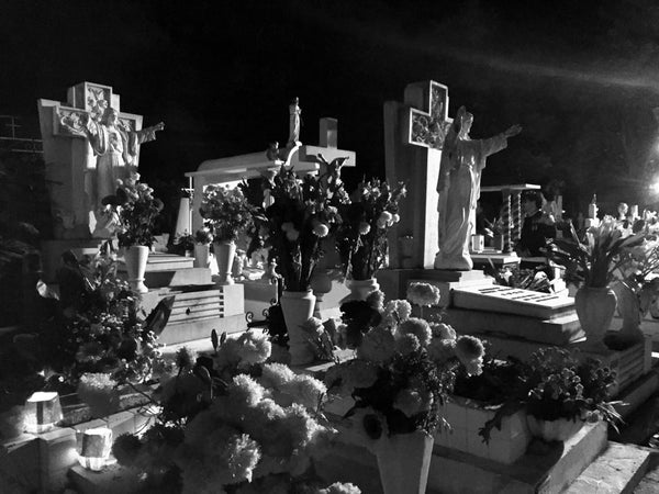 the graveyard beautifully decorated for day of the dead with flowers and saints.