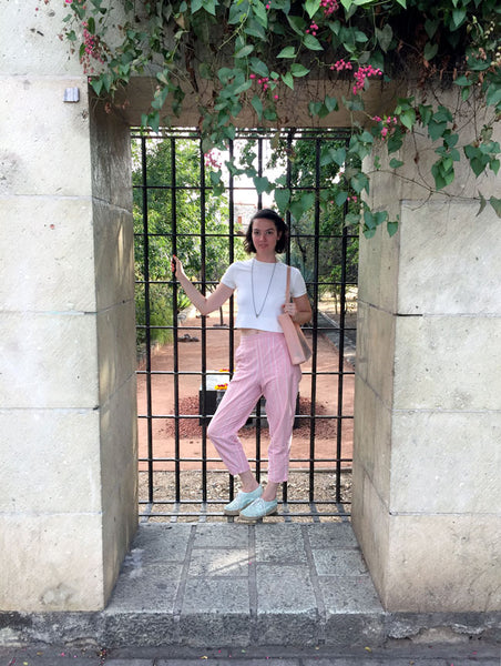 full body of a person standing at a window into the secret garden of santo domingo.