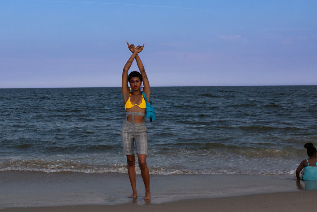 model posing with arms up at wake on beach.