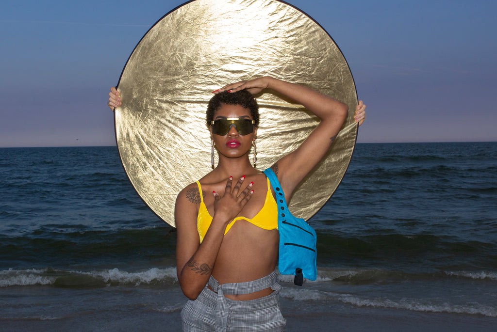 model posing on beach in front of reflector.