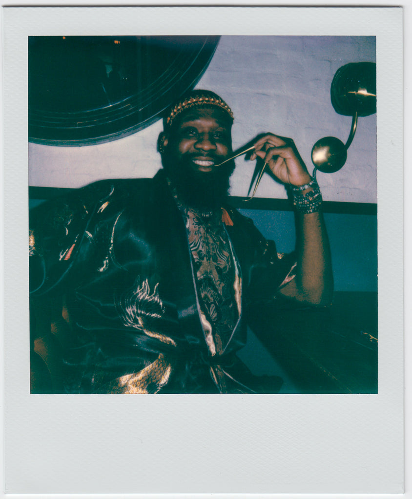 person smiling to the camera, posing with long gold nails. 