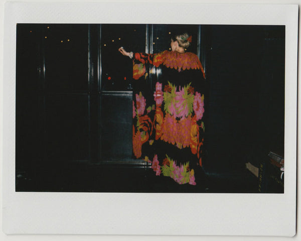 employee from the back, wearing long kimono, left arm raised - polaroid style. 