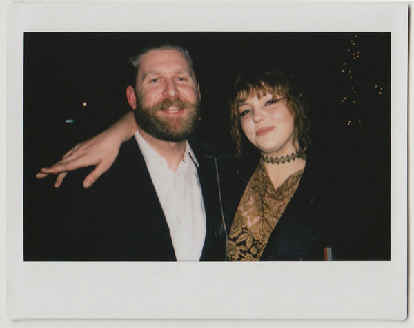 two people slightly smiling to the camera - polaroid style.