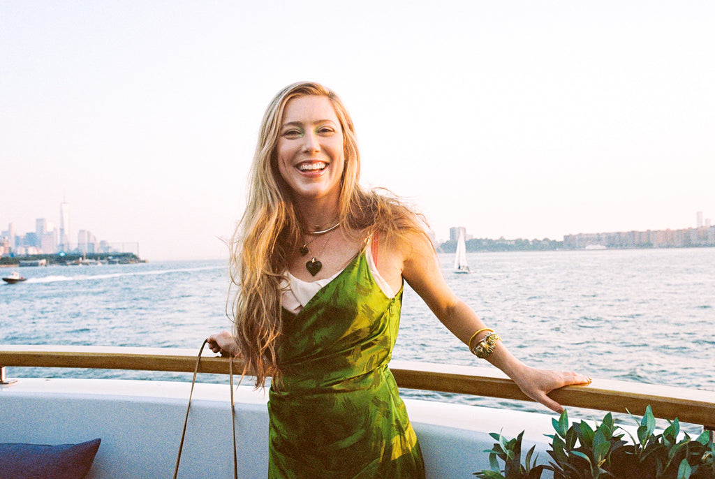 model smiling to the camera, river in the background.