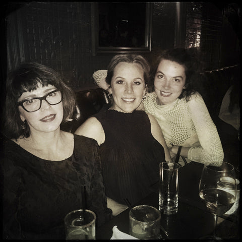 trio posing with drinks on table, above angle.