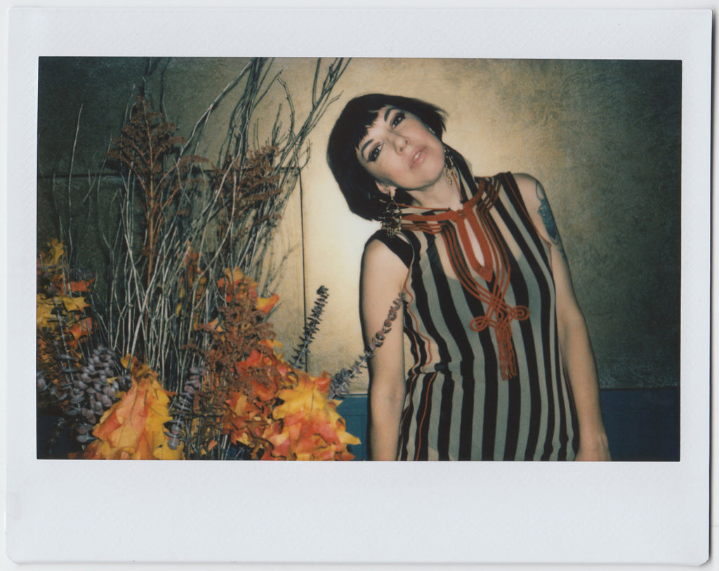 person posing next to a flower arrangement - polaroid style.