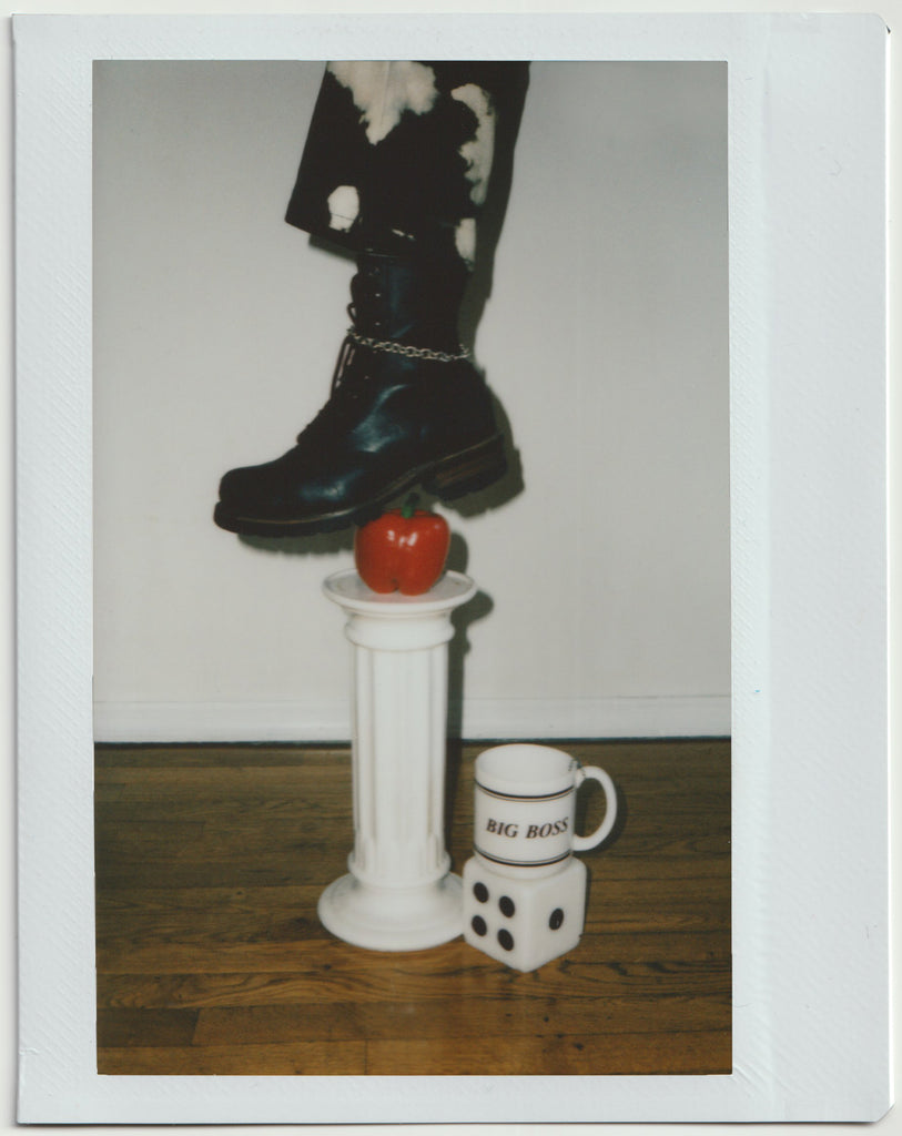 detail of boot and a bell pepper with mug that reads 'big boss' on a dice.