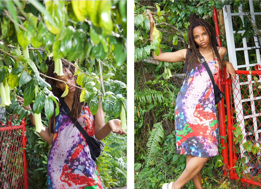 person posing next to ferns and palms.