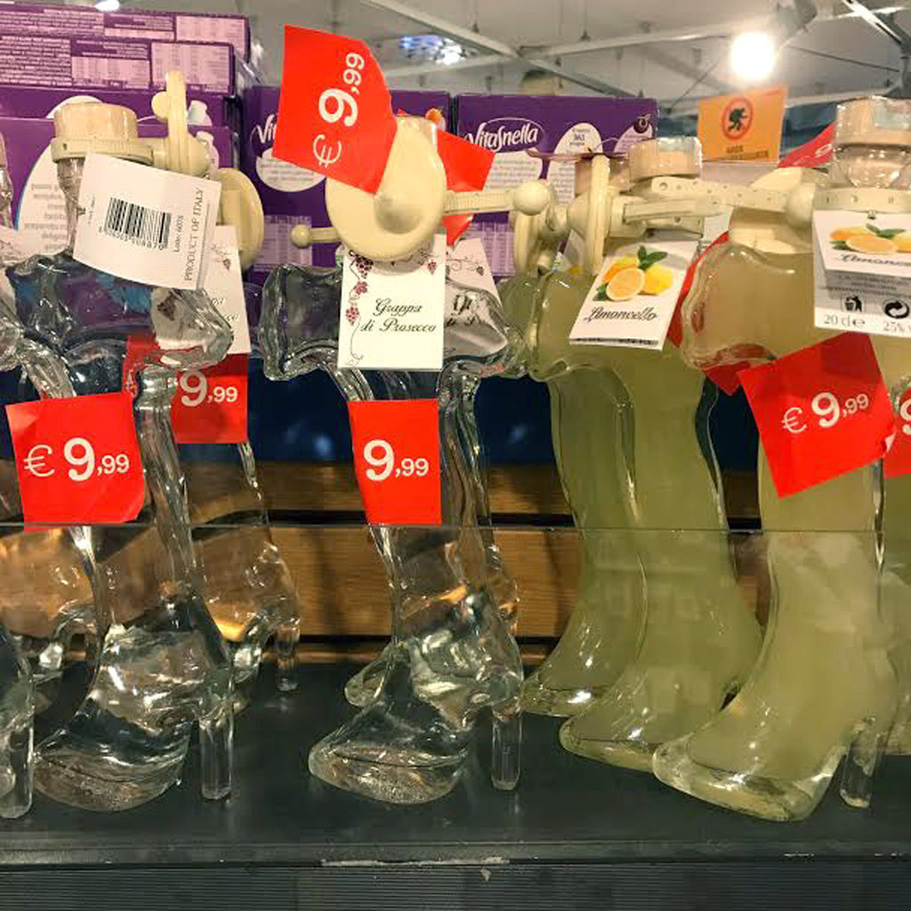 display of boots shaped bottles of wine on a shelf.