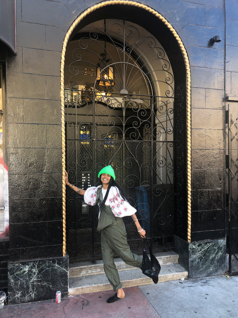 crystal anderson leaning on building doorway with leg up.