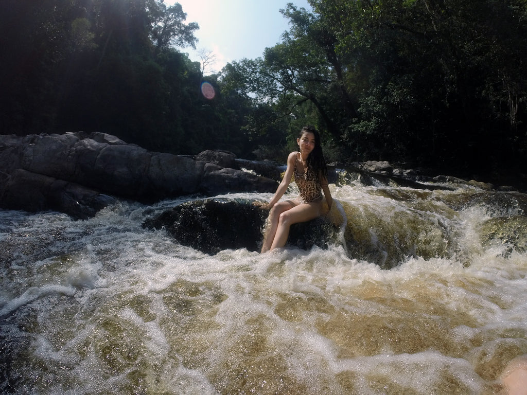 a person sitting in the rocks at cascade falls. 