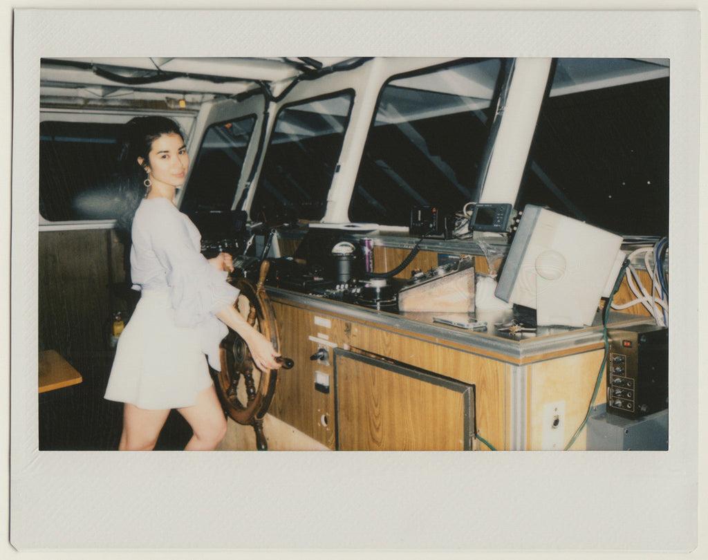 employee posing at the helm of the boat - polaroid style. 