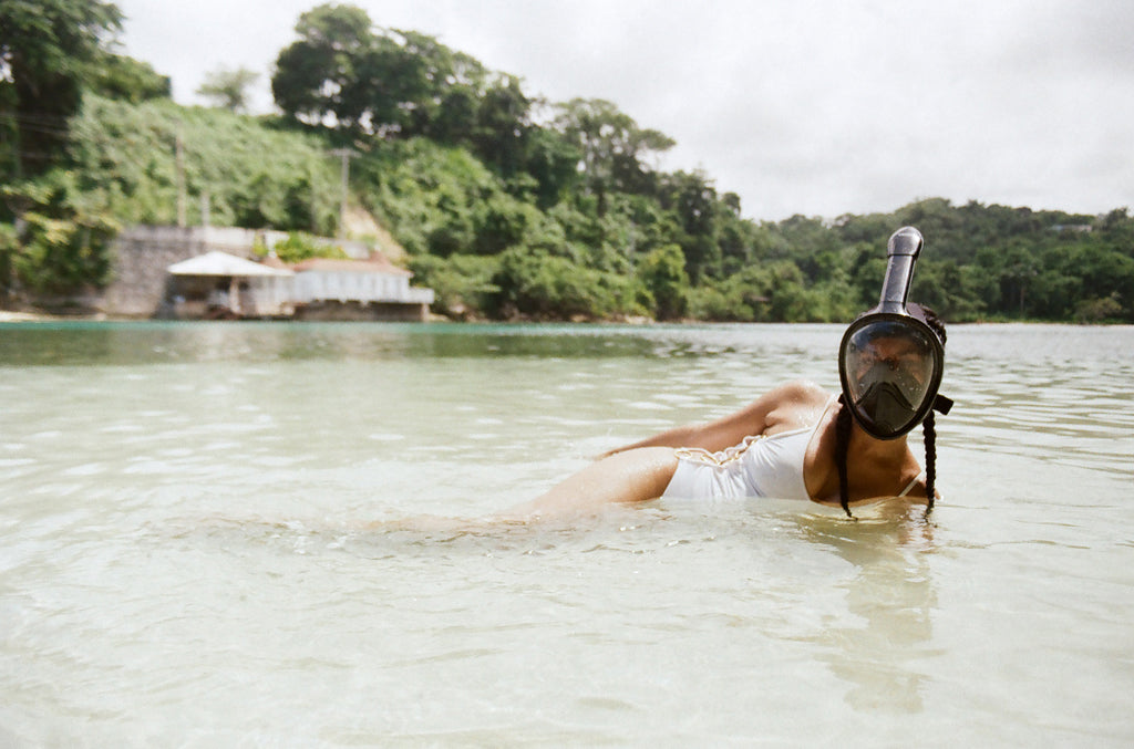 a person laying in the water with a snorkling mask.