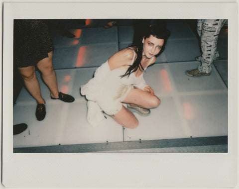 employee posing to the camera on the dance floor from above - polaroid style.