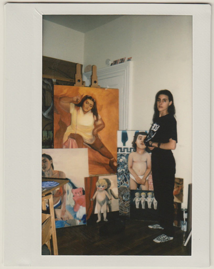 phaedra posing in front of her paintings.