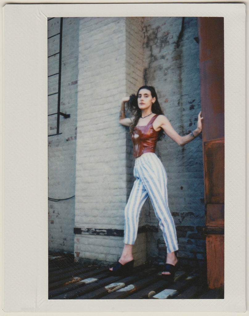 phaedra posing on the roof in striped pants.