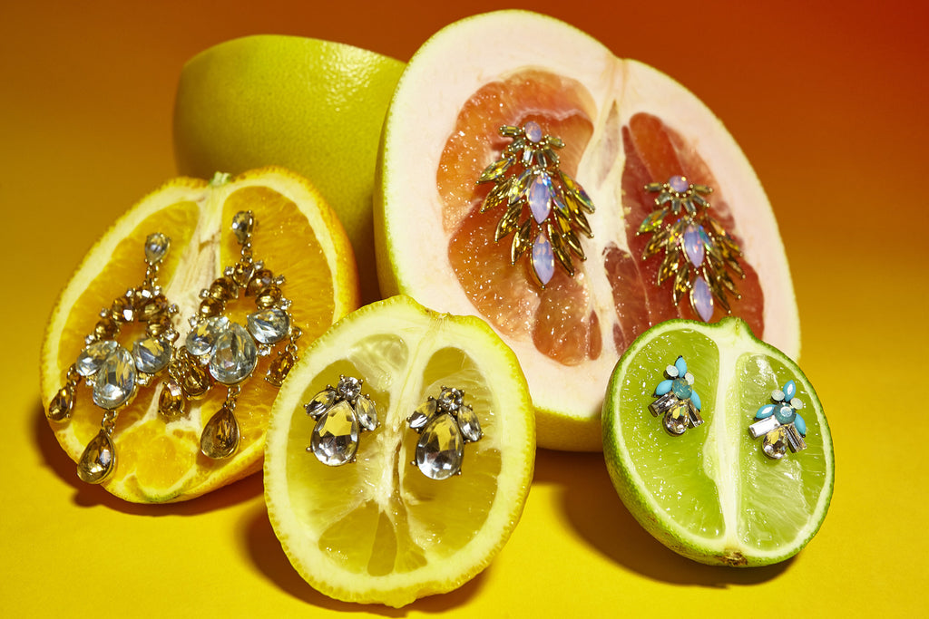 still life featuring citrus and earrings.