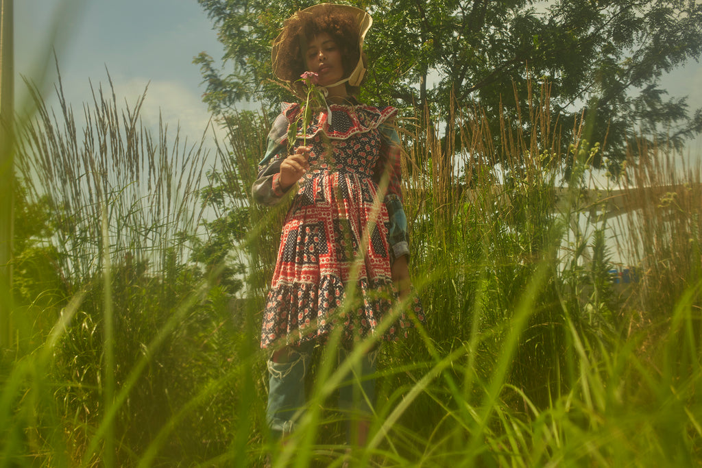 model posing in grass and flowers.