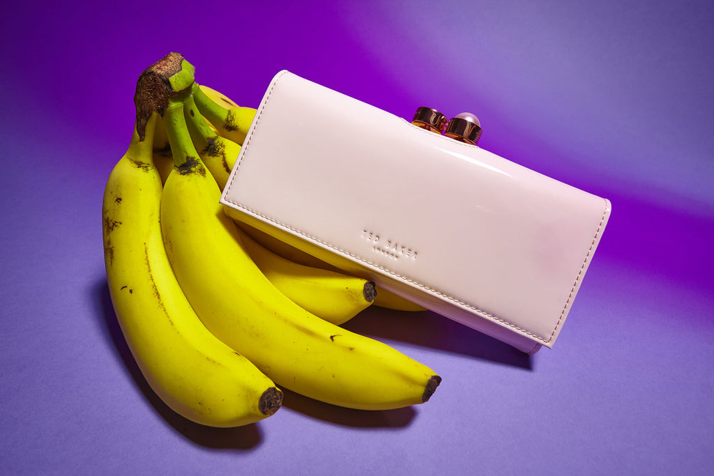 still life of ted baker wallet and banana bunch.