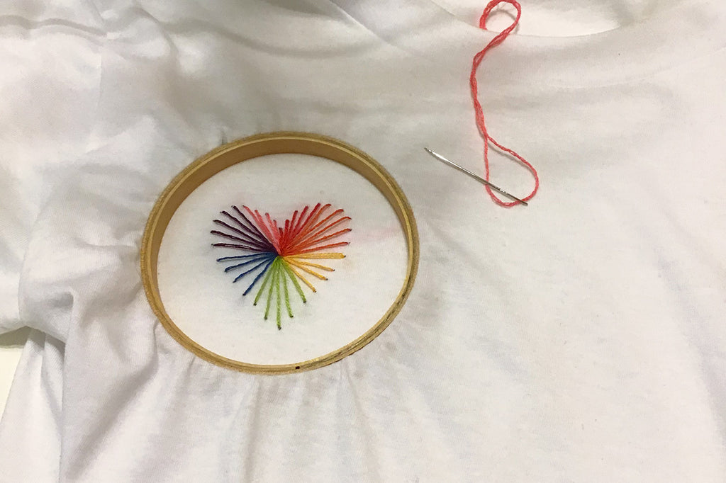 Heart strings stitched on white t-shirt with embroidery hoop