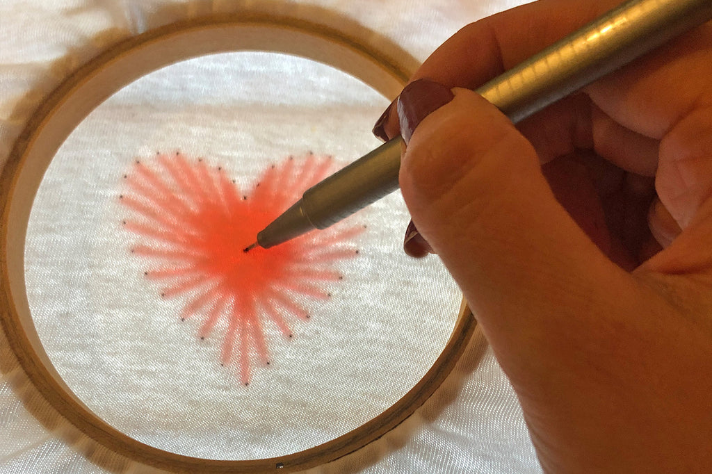 Tracing heart strings design onto t-shirt for stitching