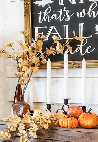 Vignette of fall seed pods and leaved stems, candles and small pumpkins