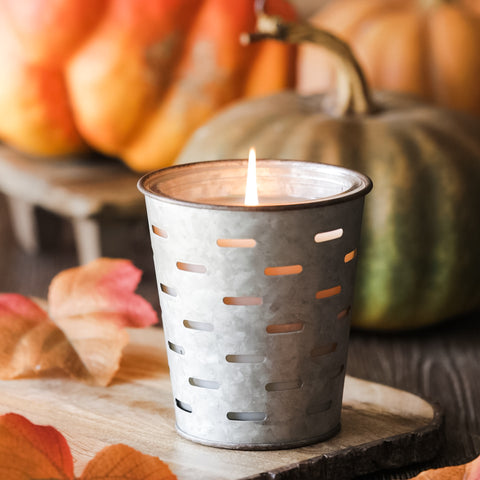 Autumnal candle in mini, galvanized, olive bucket with pumpkin backdrop