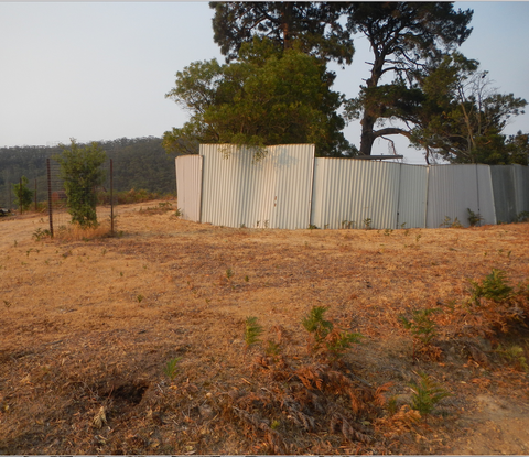 main wombatorium, soaked with water, cleared of burnables, water and food for a week in metal containers 