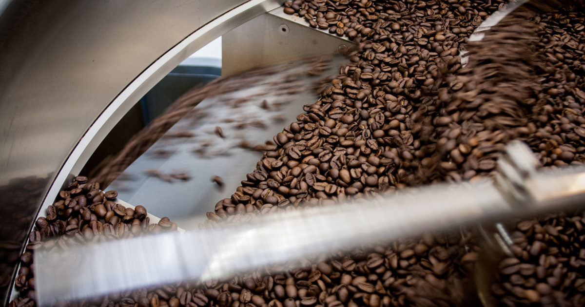 roasted coffee in a cooling tray in the process of being dumped out of the cooling tray