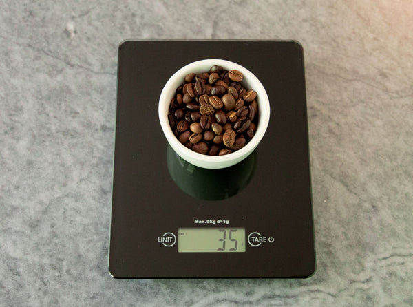 cà phê được cân trên cân đen trên cân