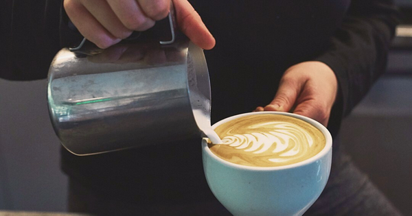 Pouring cream into coffee cup