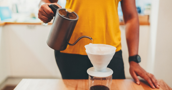 Man mindfully making a cup of pour over coffee as he starts his day.
