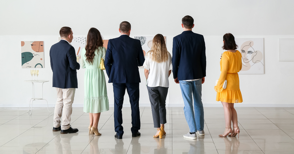 A group of people at a museum, admiring the art in the gallery.