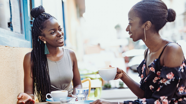 Two african women at a cafe drinking coffee