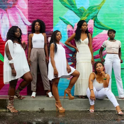 nurturing friendships, beautiful black women in white in front of a mural