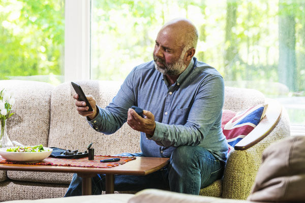 Man sitting on sofa with Glucose test