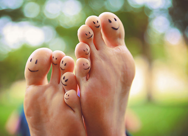 Feet with happy faces drawn on the toes