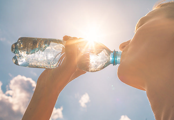 Woman drinking from plastic bottle.