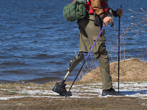 Man walking in winter with a prosthetic leg.
