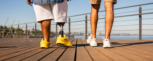 Two people walking along a boardwalk.