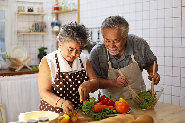 Older couple preparing a healthy meal.