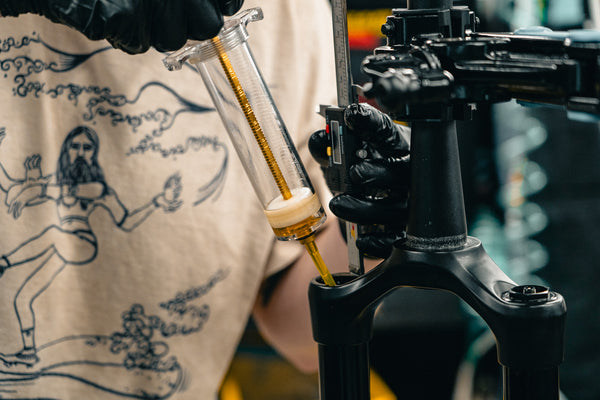 rockshox fork rebuild damper service being performed with suspension oil syringe and calipers to measure oil depth