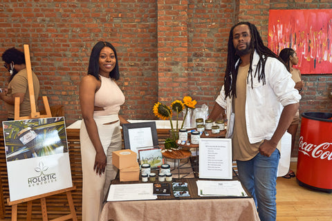 Owners of Holistic Remedies LLC, Tosin Ajayi and Isaiah Hill, posing for a photo with their CBD products
