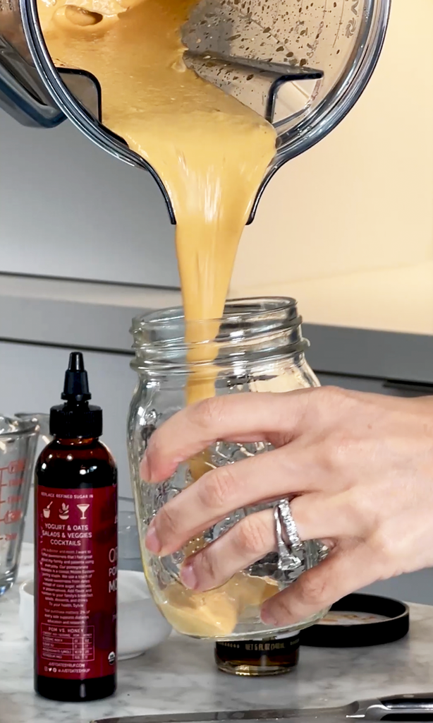 pouring kimchi dressing into glass jar