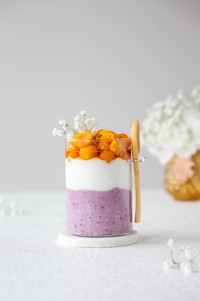 parfait with blueberry overnight oats topped with coconut yogurt and golden berries