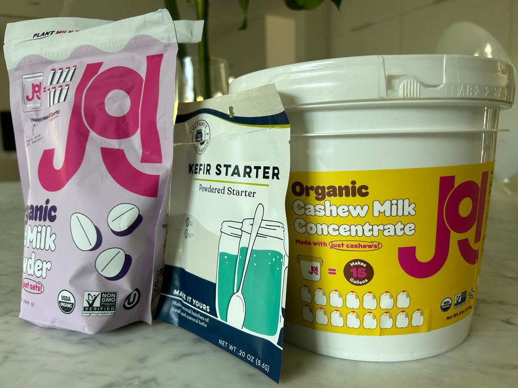 bag of JOI oat milk powder along a bag of Cultures for health kefir starter and a bucket of JOI cashew milk concentrate