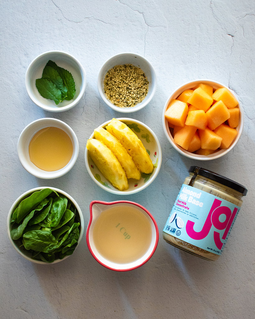 flat lay of ingredients for melon smoothie, including mint and joi and pineapple